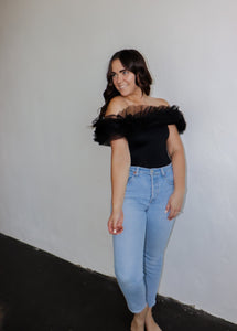 model wearing the crazy in love bodysuit in the color black. model has the top paired with a pair of light wash denim.