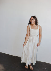 model wearing the on the bay maxi dress. model has the dress paired with a pair of neutral flatbed sandals.