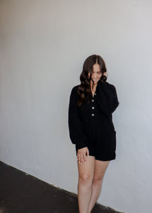 model wearing the before you go knit sweater romper in the color black.