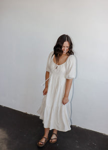model wearing the low tide maxi dress. model has the dress paired with a pair of neutral flatbed sandals.