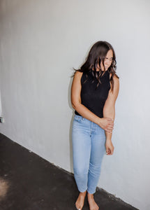 model wearing the simple love top in the color black. model has the top paired with a pair of light wash denim.