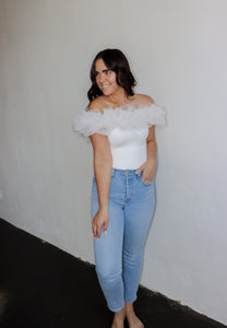 model wearing the crazy in love bodysuit in the color white. model has the top paired with a pair of light wash denim.