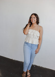 model wearing the by the shore top. model has the top paired with a pair of lightwash denim and neutral flatbed sandals.