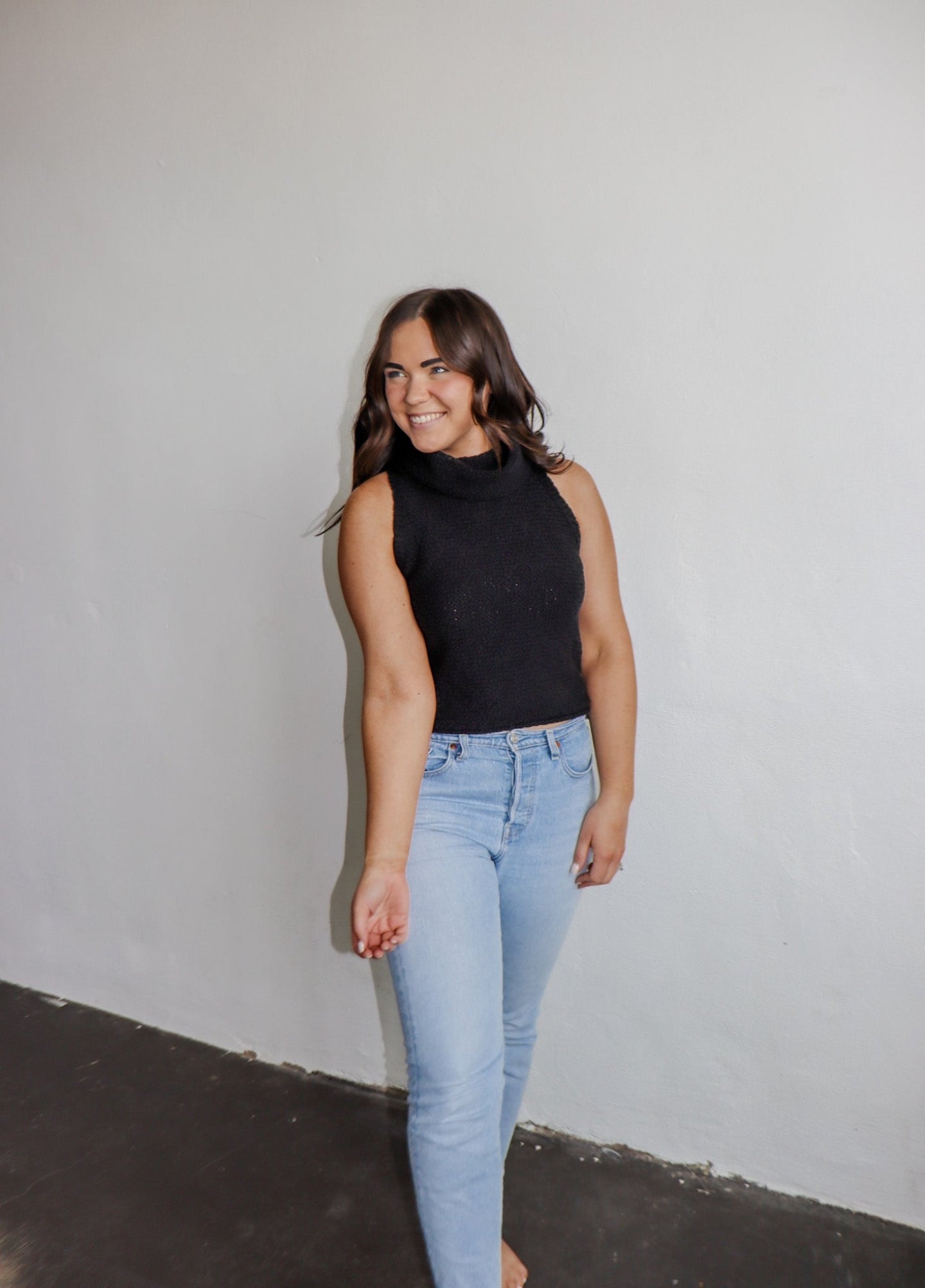 model wearing the simple love top in the color black. model has the top paired with a pair of light wash denim.
