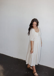 model wearing the low tide maxi dress. model has the dress paired with a pair of neutral flatbed sandals.