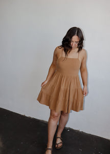 model wearing the sand dunes mini dress. model has the dress paired with a neutral pair of flatbed sandals.