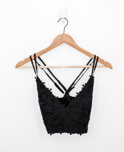 front view of always knew floral lace bralette in the color black, pictured on a wooden hanger with a white backdrop