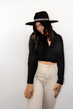 Load image into Gallery viewer, model wearing the all this time top paired with a pair of cream colored denim jeans and a black rancher style hat. model is smiling, looking downward and off toward the side, and resting her hands on her thighs.