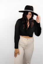 Load image into Gallery viewer, model wearing the all this time top paired with a pair of cream colored denim jeans and a black rancher style hat. model is smiling, looking off toward the side, and resting one hand on her hat and the other on her thigh.