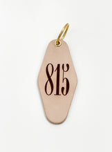 Load image into Gallery viewer, photo of leather motel style keychain with 815 markings on the face of the keychain and gold hardware