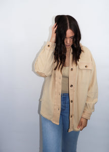 model wearing the until then jacket. model has the jacket paired with a pair of denim and is looking downward.