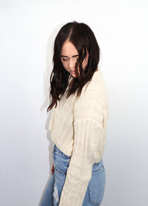 model wearing the how the story goes sweater paired with high-waisted denim jeans
