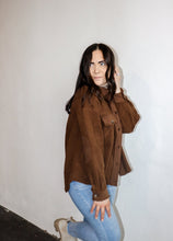 Load image into Gallery viewer, model wearing the never look back jacket in the color brown. model has the jacket paired with the can&#39;t get enough top in the color oatmeal and a pair of denim.