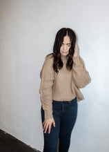 Load image into Gallery viewer, model wearing the patiently waiting sweater in the color oat. model has the sweater paired with a pair of black denim.