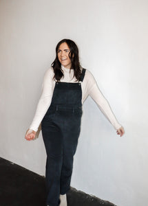 model wearing the sweet disposition overalls in the color charcoal. model has the overalls paired with the by your side top in the color cream.