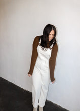 Load image into Gallery viewer, model wearing the sweet disposition overalls in the color cream. model has the overalls paired with the by your side top in the color espresso.