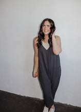 Load image into Gallery viewer, model wearing the never felt this way jumpsuit in the color washed black. model has the jumpsuit paired with the these days top in the color chalk and a pair of platform sneakers.