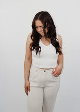 Load image into Gallery viewer, model wearing the stay the same top in the color white. model has the top paired with the chelsea linen trousers in the color oatmeal.