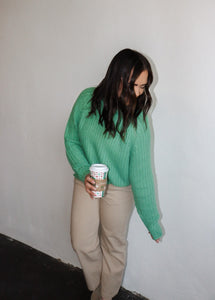 model wearing the patiently waiting sweater in the color jade. model has the sweater paired with the siena denim.