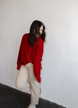 Load image into Gallery viewer, model wearing the patiently waiting sweater in the color red. model has the sweater paired with the siena denim.