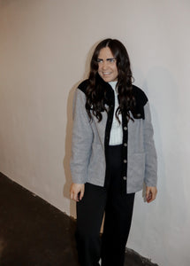 model wearing the never say never jacket in the color black/charcoal. model has the jacket paired with the all along sweater vest and the logan trousers in the color black.