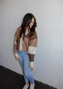 model wearing the day by day cardigan. model has the sweater paired with a pair of lightwash denim and platform sneakers.