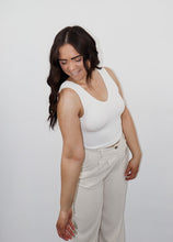 Load image into Gallery viewer, model wearing the stay the same top in the color white. model has the top paired with the chelsea linen trousers in the color oatmeal.