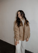 Load image into Gallery viewer, model wearing the never say never jacket in the color camel/taupe. model has the jacket paired with the by your side top in the color taupe and the chelsea linen trousers in the color oatmeal.