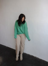Load image into Gallery viewer, model wearing the patiently waiting sweater in the color jade. model has the sweater paired with the siena denim.