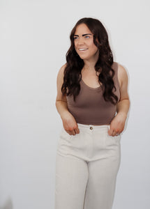 model wearing the stay the same top in the color walnut. model has the top paired with the chelsea linen trousers in the color oatmeal.